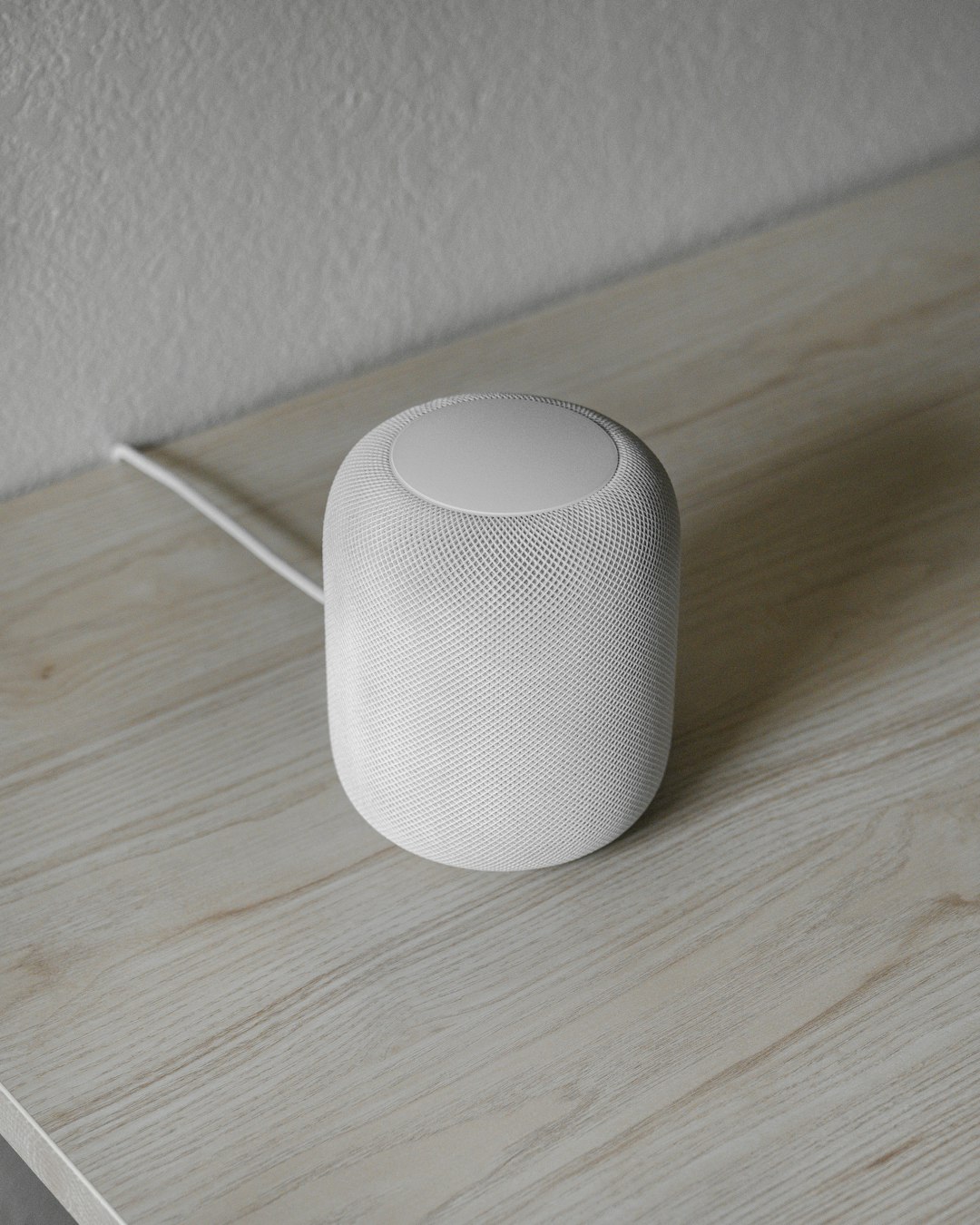 white round portable speaker on brown wooden table