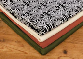 A neat stack of wellness printables with botanical illustrations resting on a cream linen cloth.