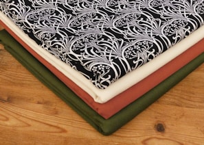 Stack of folded Mexican-style woven garments on wooden table