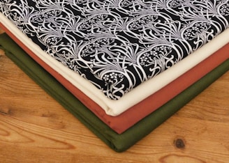 Stack of folded Mexican-style woven garments on wooden table