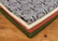 Stacks of soft, patterned textiles folded on a wooden table.