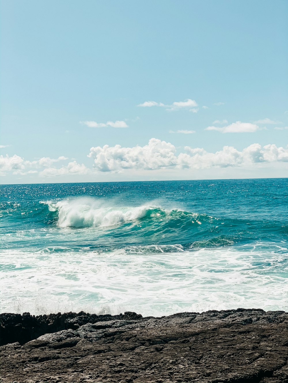 ondas do oceano batendo na costa rochosa durante o dia
