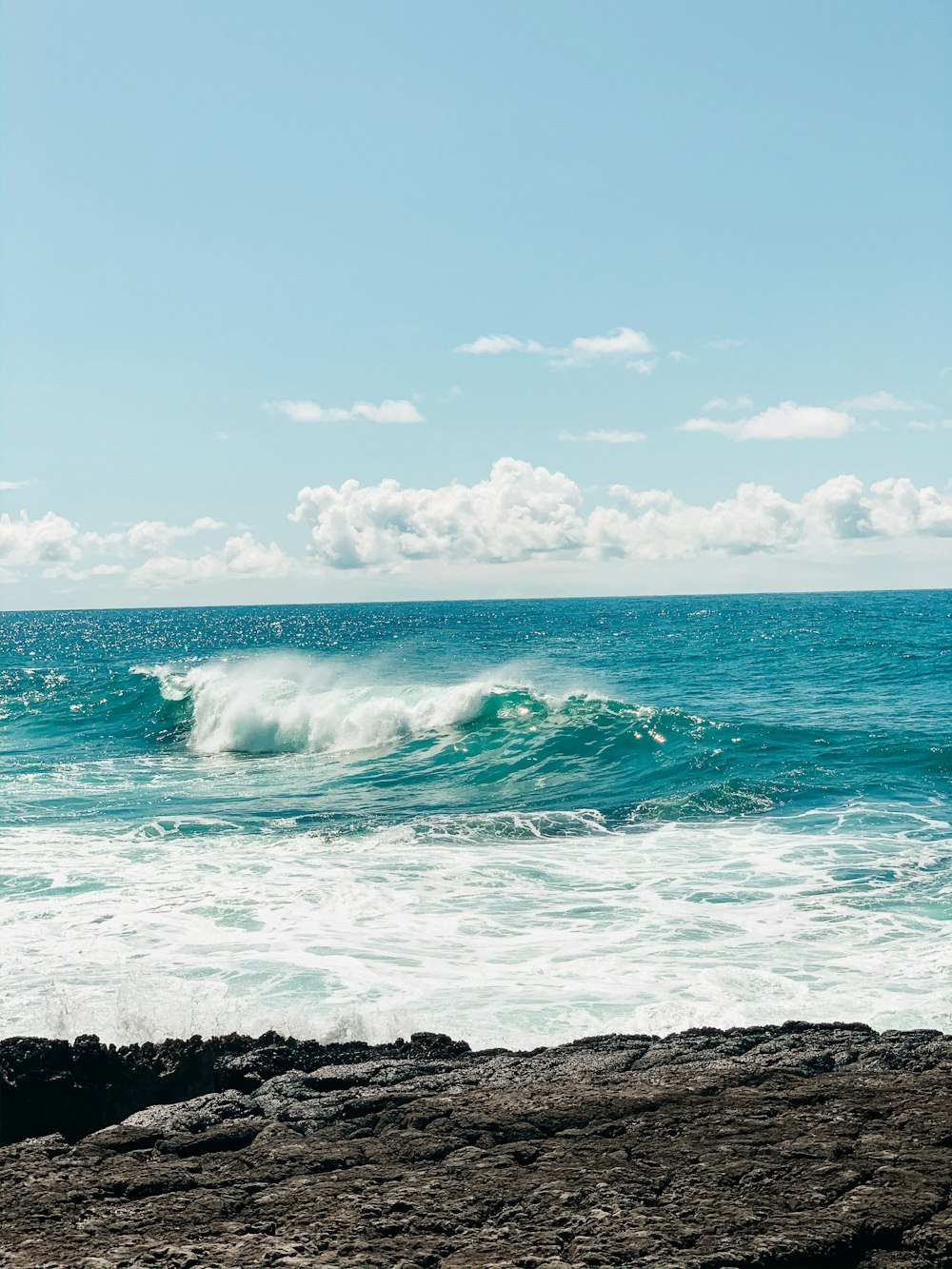 ocean waves crashing on rocky shore during daytime