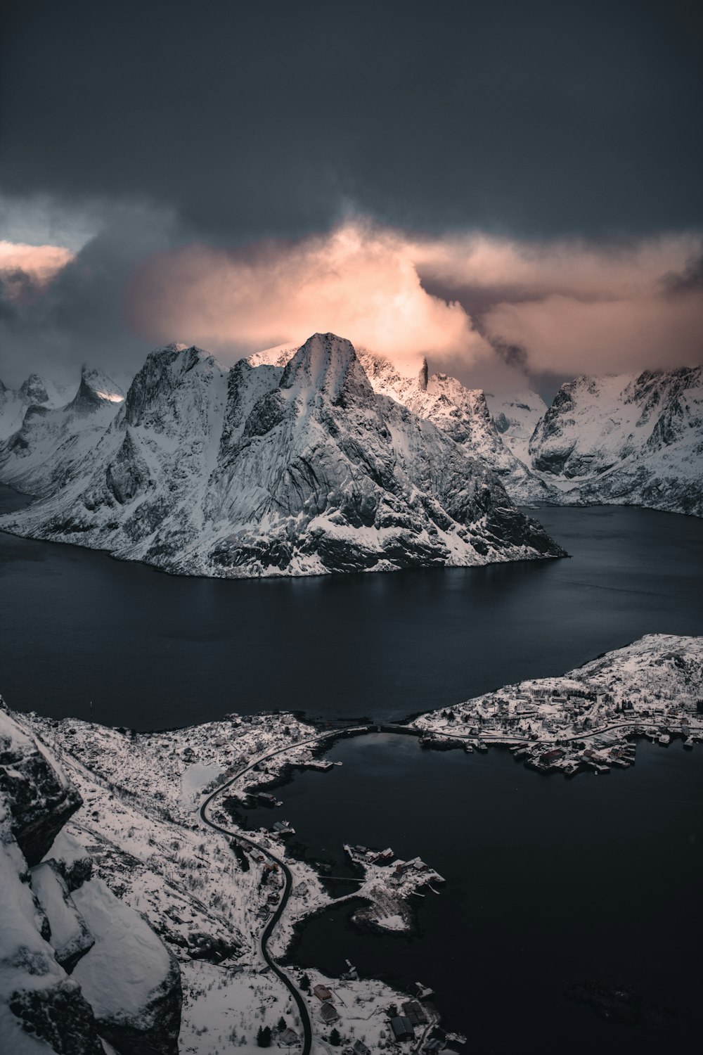 montagna coperta di neve vicino allo specchio d'acqua durante il tramonto