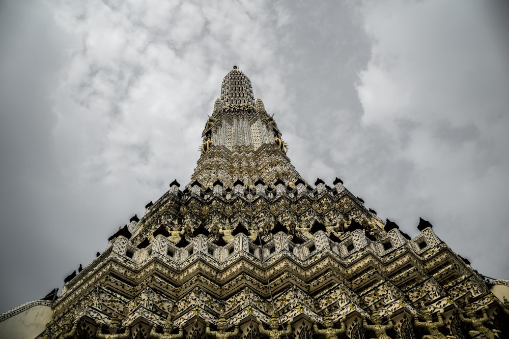 Edificio de hormigón dorado y blanco bajo nubes blancas