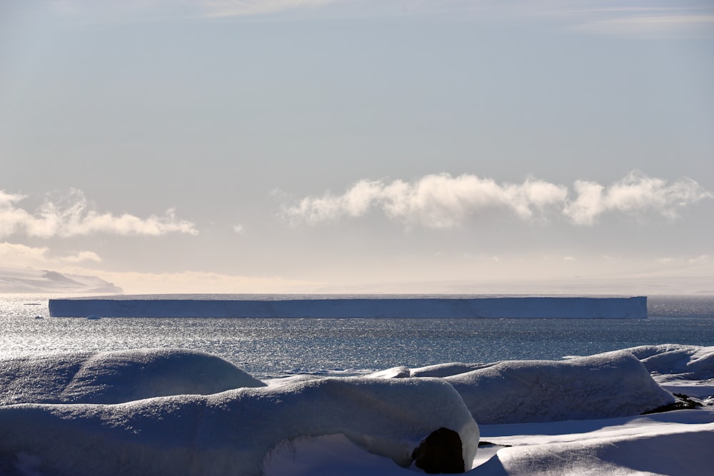 snow covered field under cloudy sky during daytime