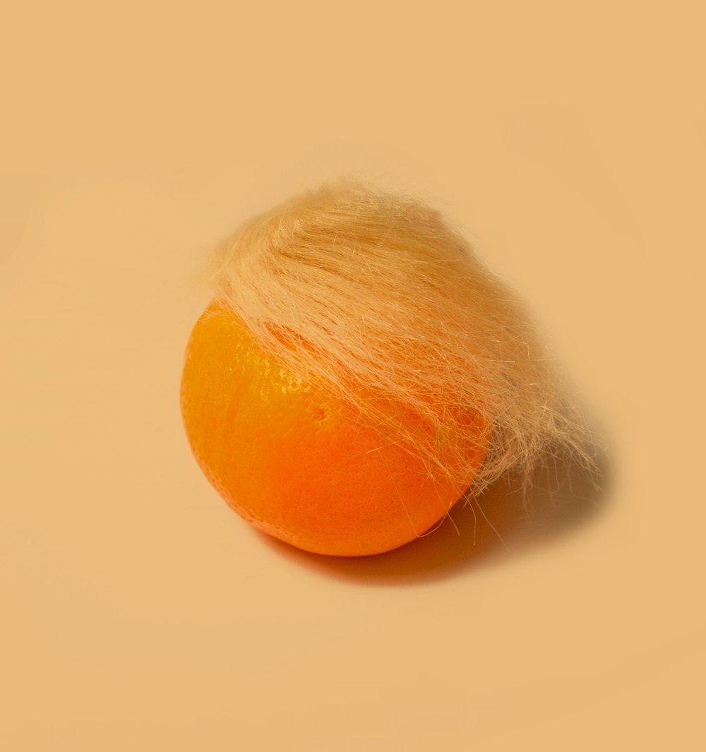 fruto anaranjado sobre superficie blanca