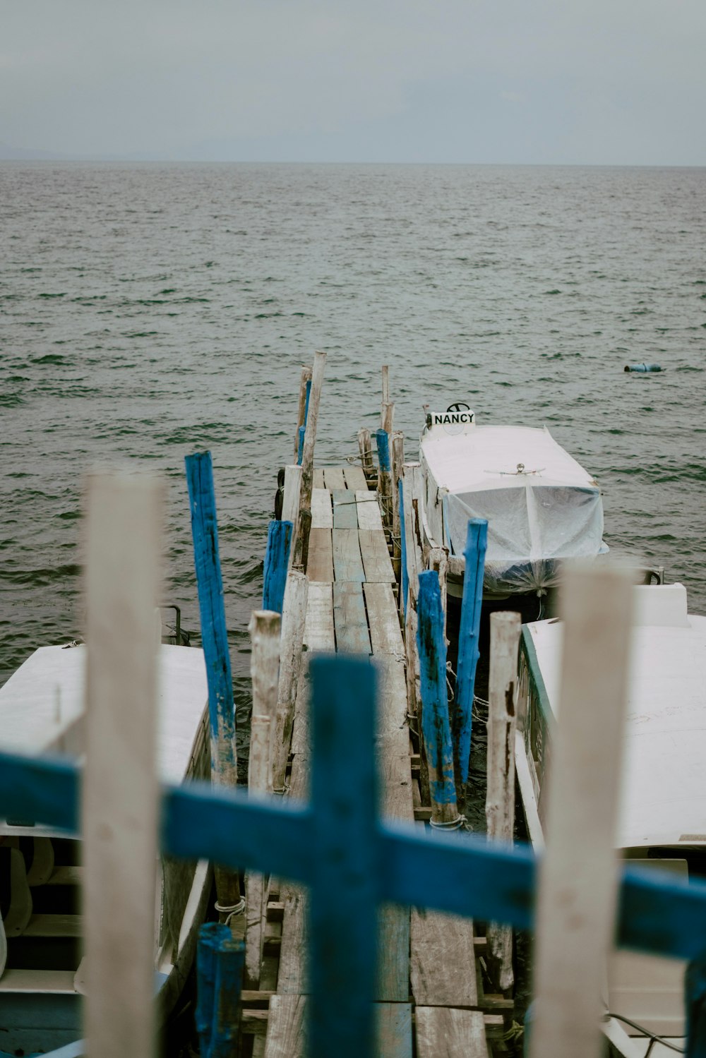 blue metal fence near body of water during daytime