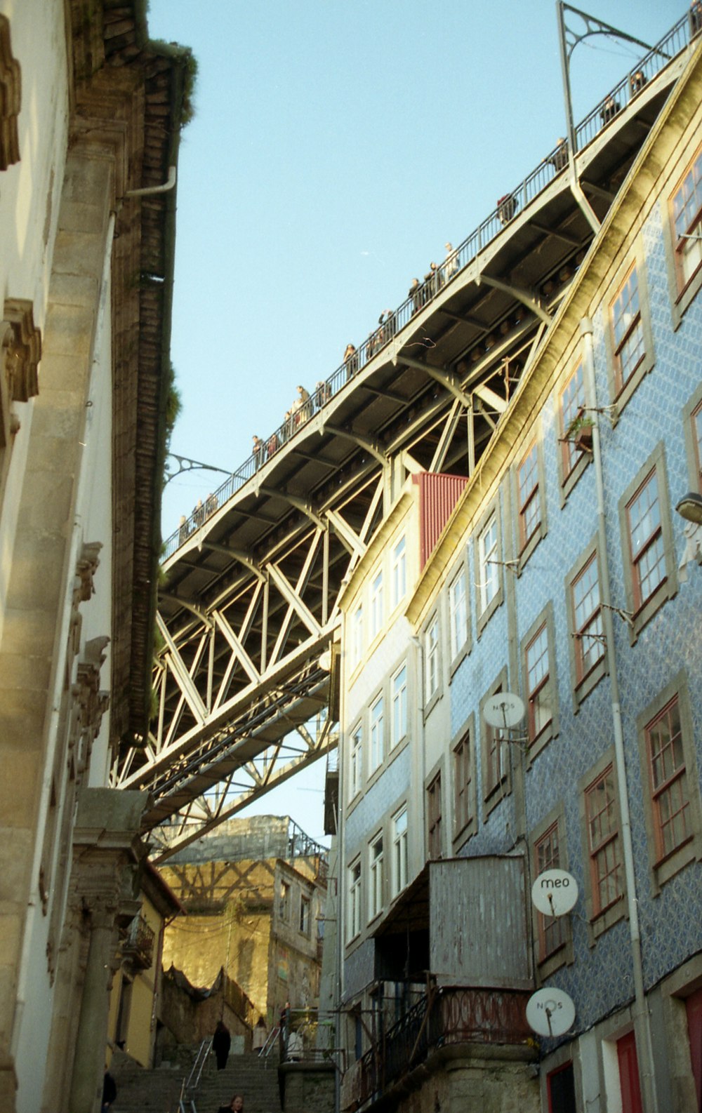 brown metal bridge near brown concrete building during daytime