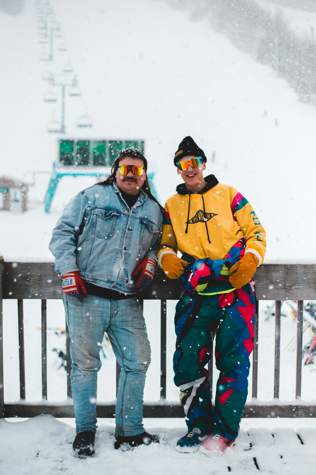 man in yellow jacket and blue denim jeans standing beside boy in yellow jacket