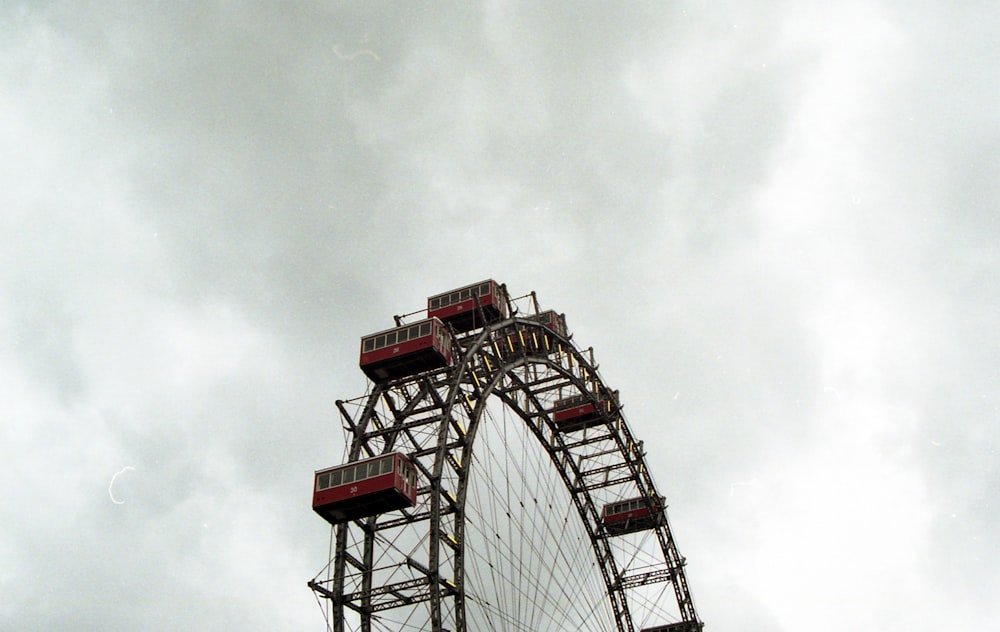 rueda de la fortuna roja y blanca bajo el cielo nublado durante el día