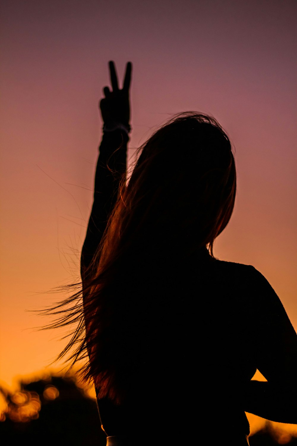 silhouette of woman raising her right hand