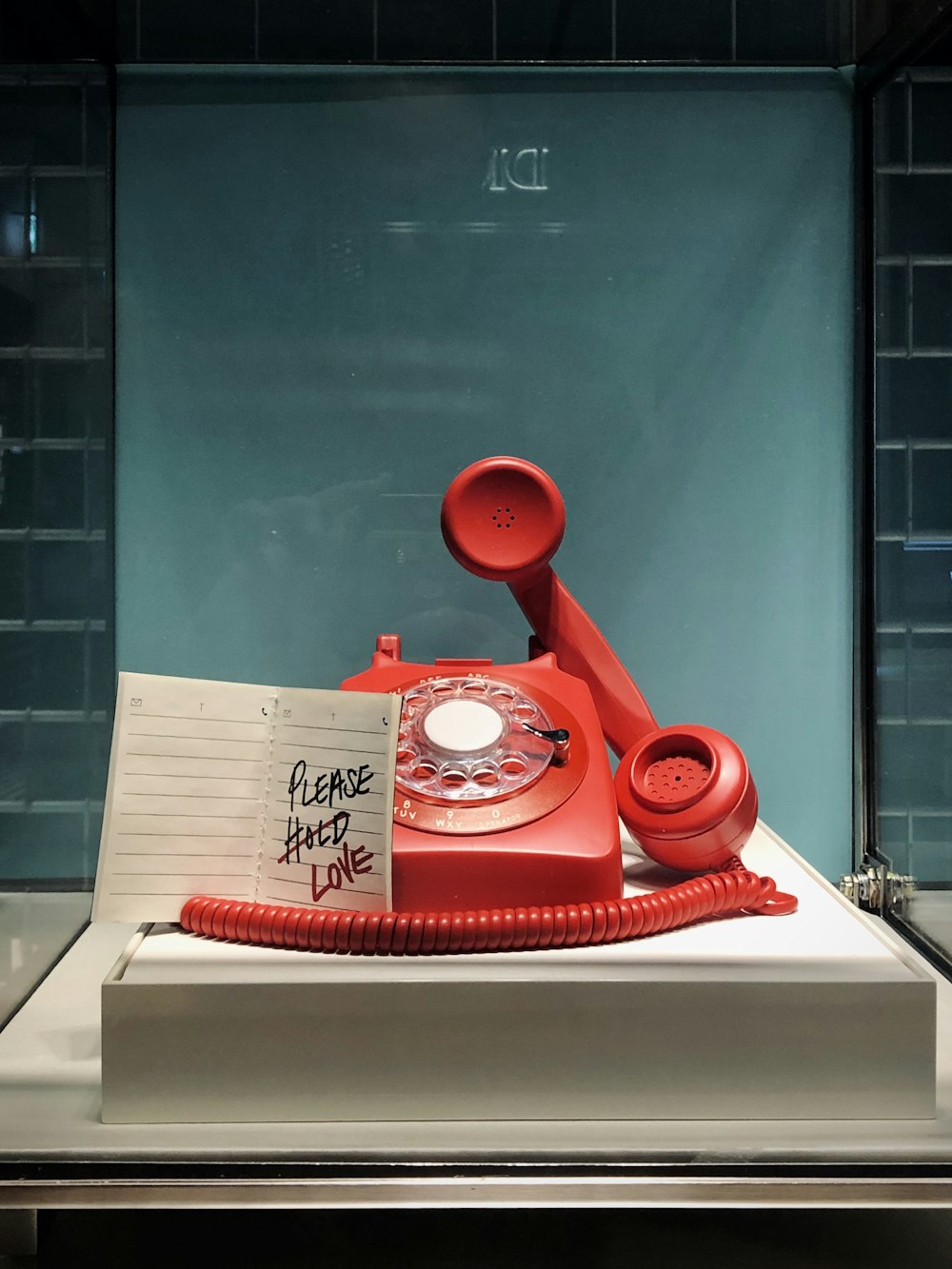 red and white rotary telephone on white table