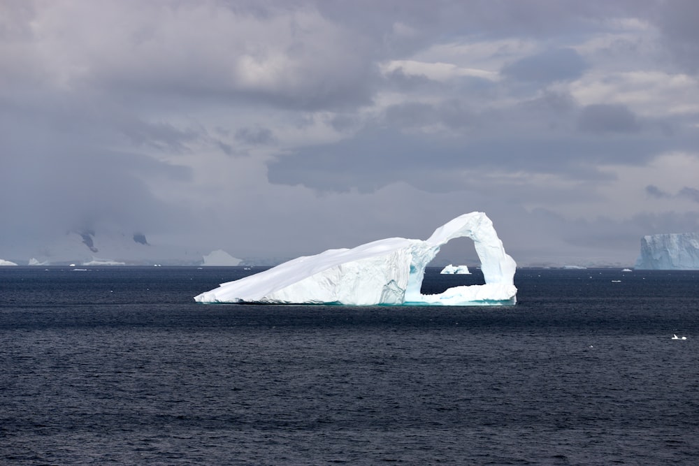 brown rock formation on sea under cloudy sky during daytime