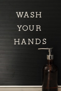 Close-up of a hand wash station with soap dispenser and paper towels ready for use.