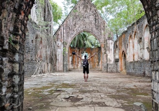 woman in black long sleeve shirt and black skirt standing on gray concrete pathway during daytime