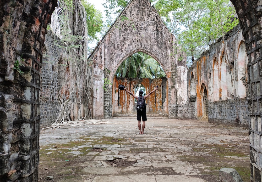 woman in black long sleeve shirt and black skirt standing on gray concrete pathway during daytime