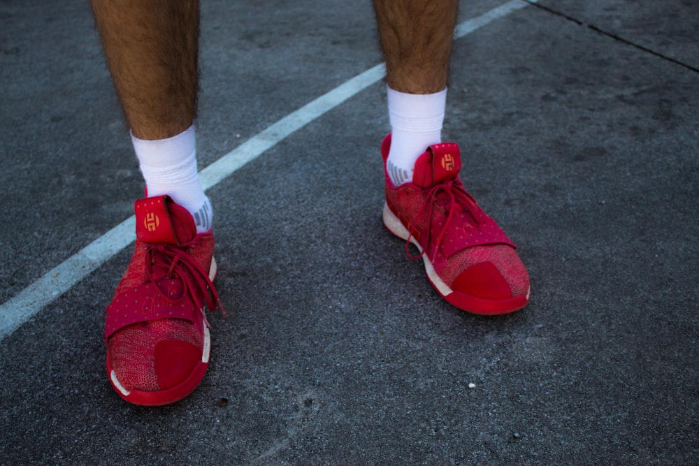 person in red and white nike sneakers