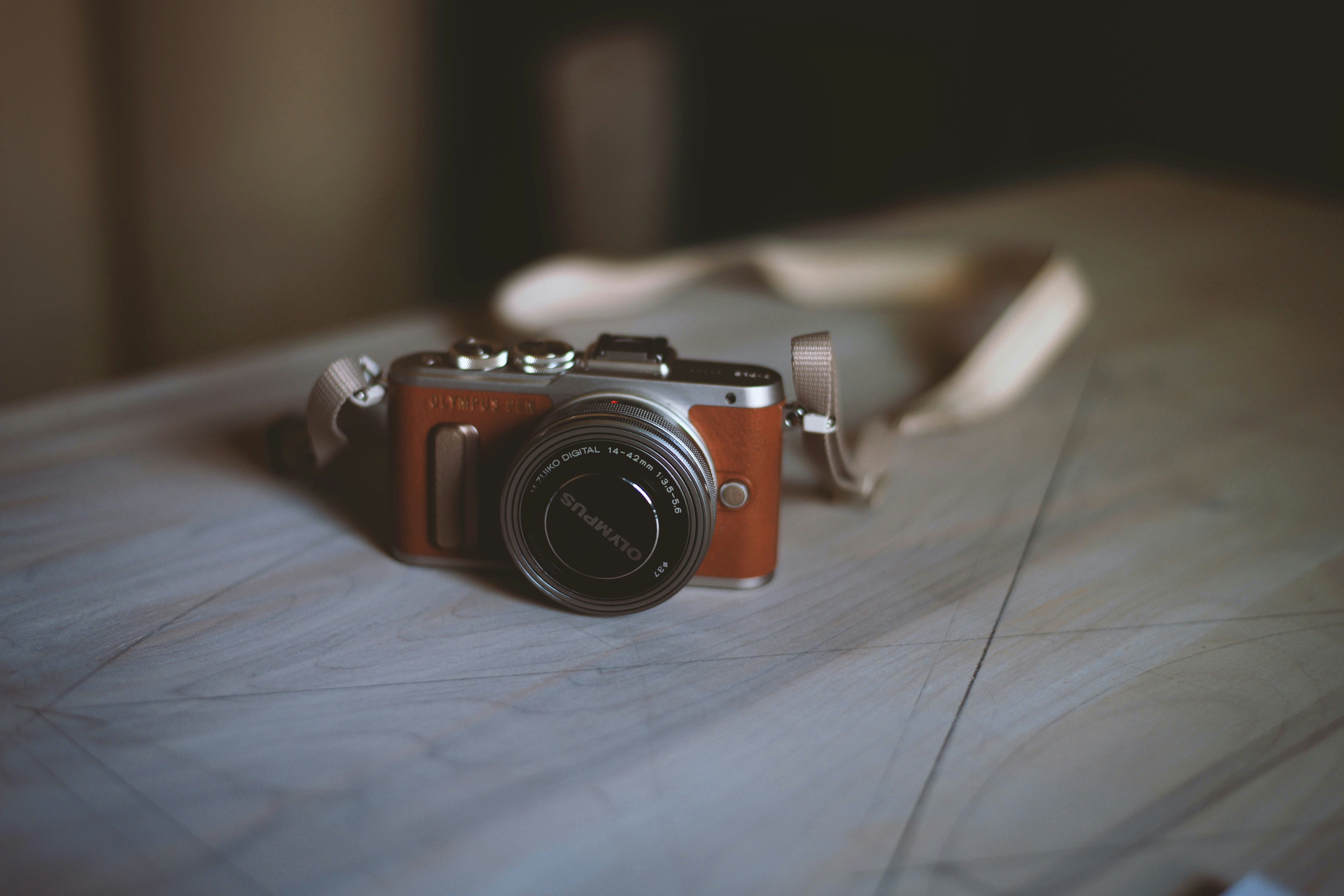 brown and silver camera on brown wooden table