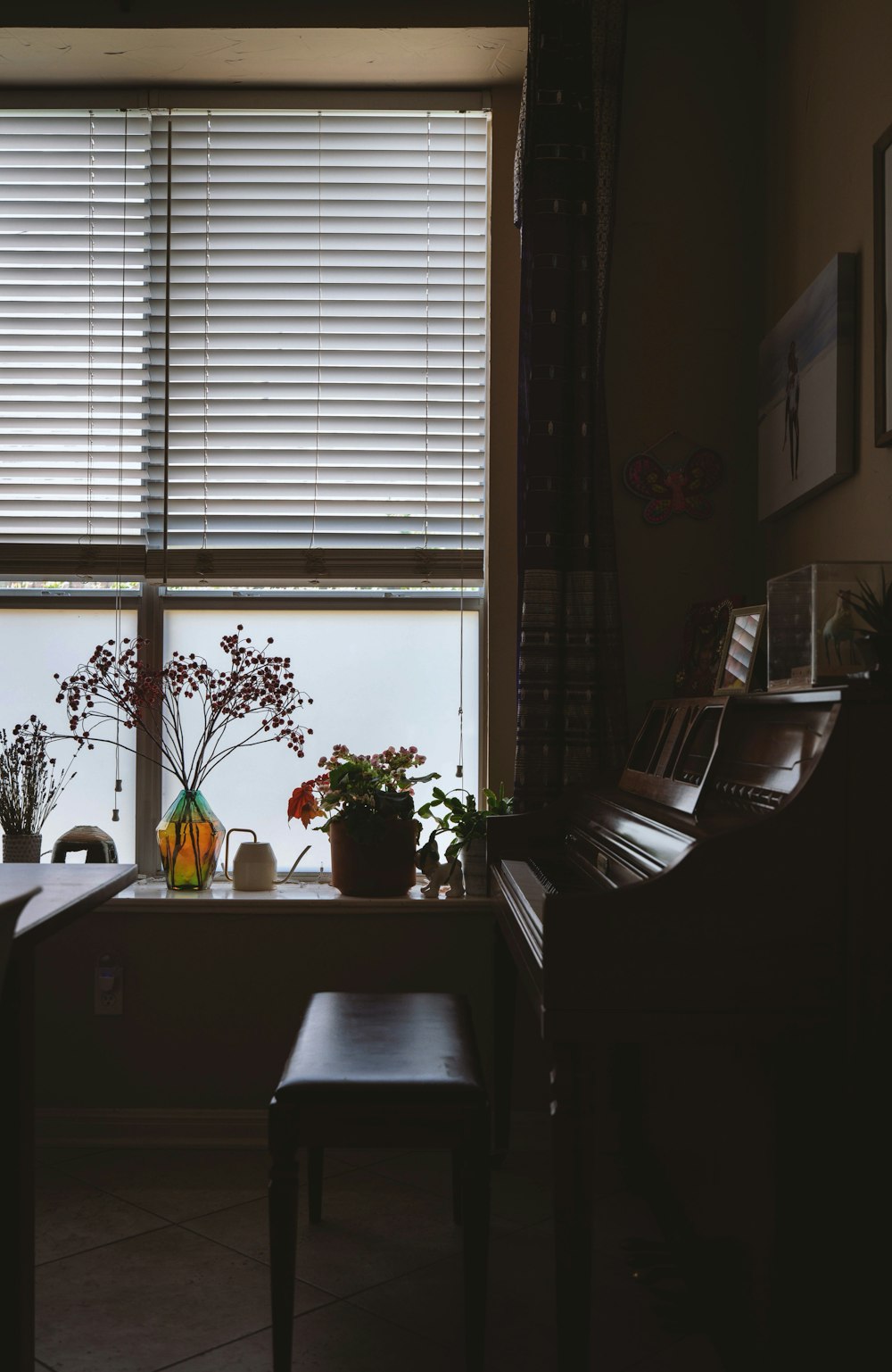 black upright piano near window