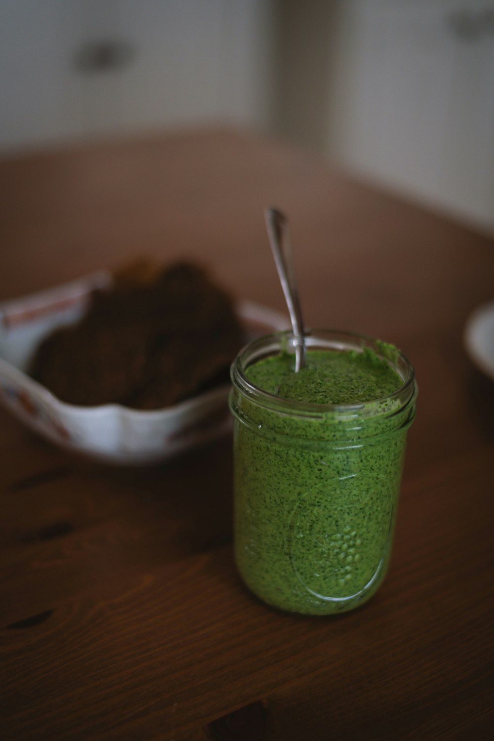 green glass jar on brown wooden table