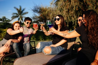 woman in black shirt and blue denim jeans sitting on brown wooden bench with girl in on on on on