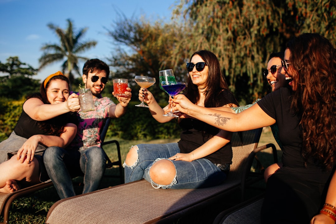 woman in black shirt and blue denim jeans sitting on brown wooden bench with girl in on on on on