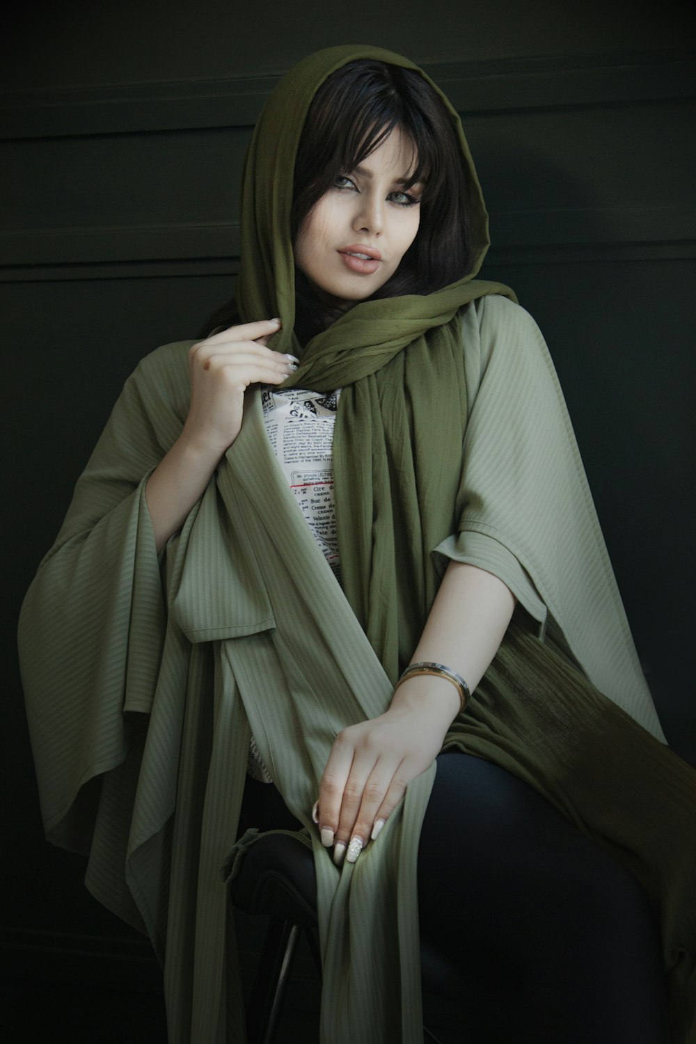 mulher no hijab verde sentado na cadeira preta