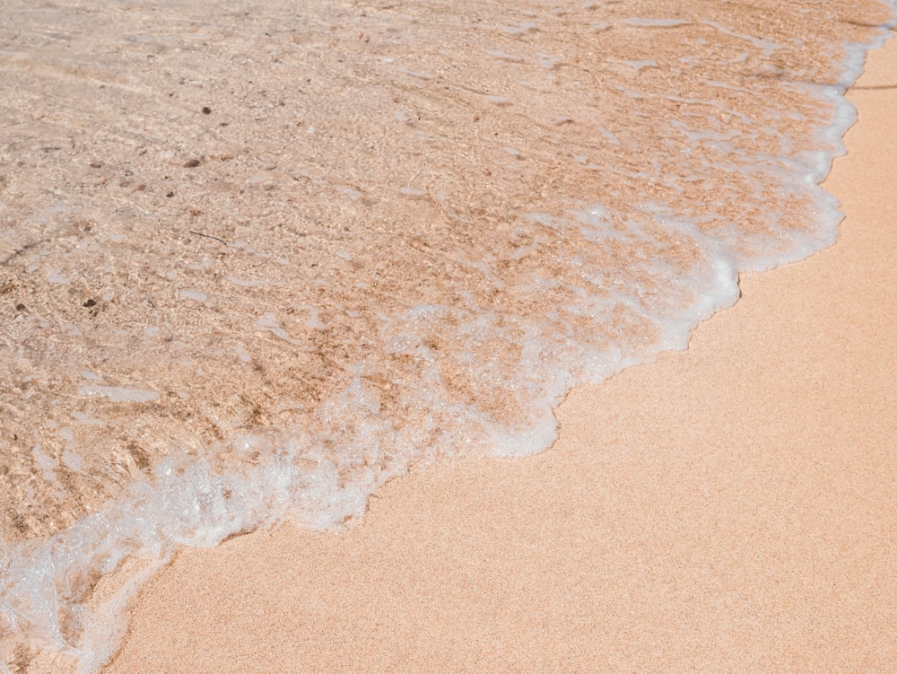 brown sand near body of water during daytime