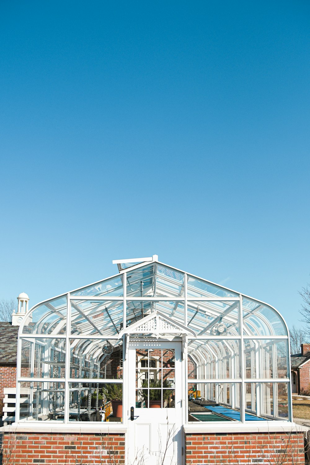 Weißmetallgerahmtes Glasgebäude unter blauem Himmel tagsüber