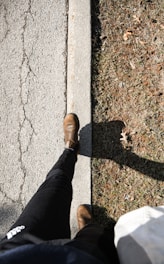 a person standing on a sidewalk with their feet on the ground