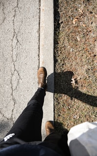 a person standing on a sidewalk with their feet on the ground