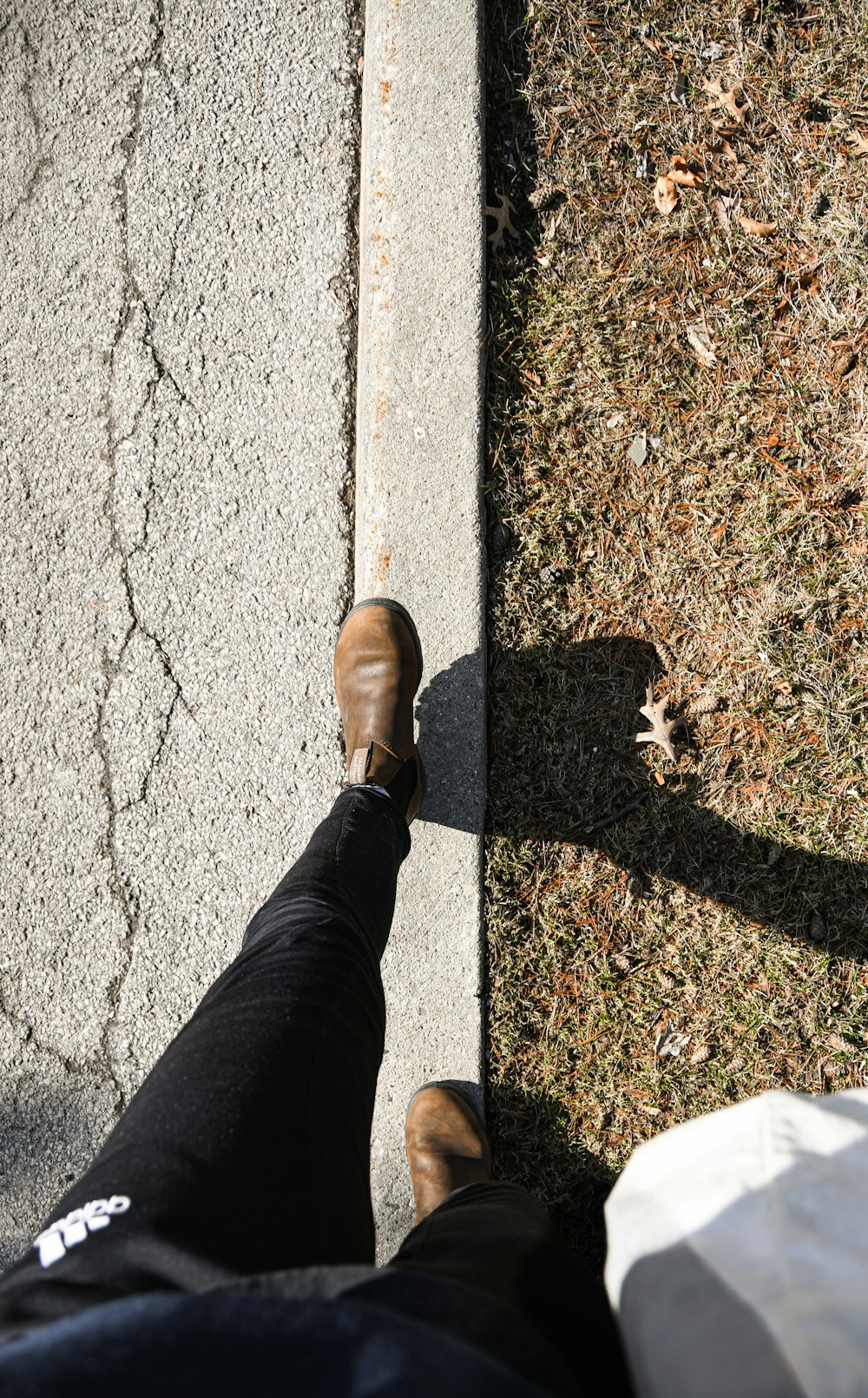 uma pessoa de pé em uma calçada com os pés no chão