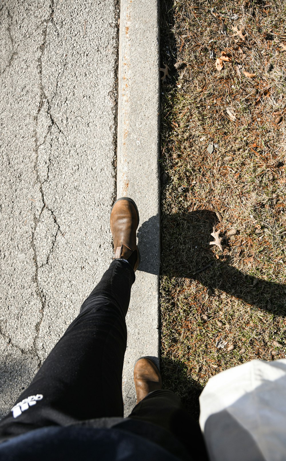 a person standing on a sidewalk with their feet on the ground