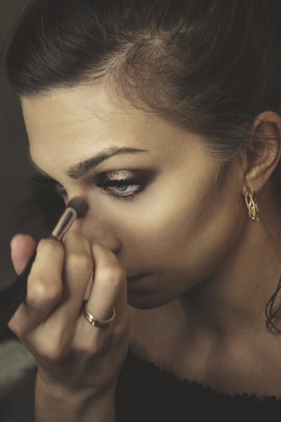 woman in gold earrings holding her lip