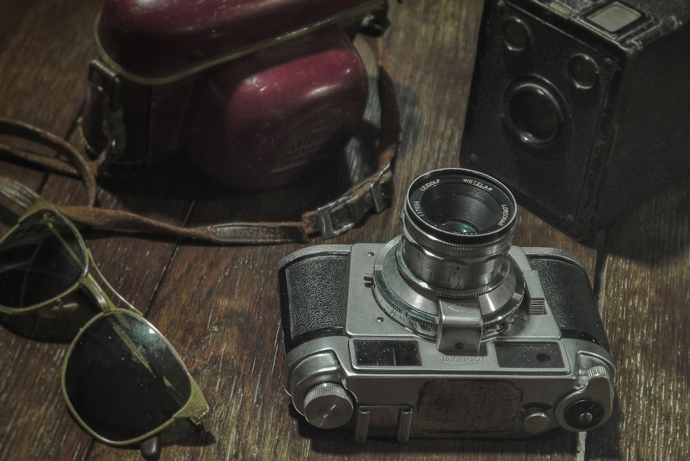 black and silver dslr camera on brown wooden table