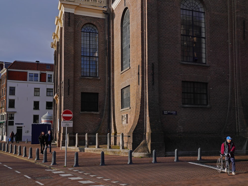 people walking on sidewalk near brown concrete building during daytime