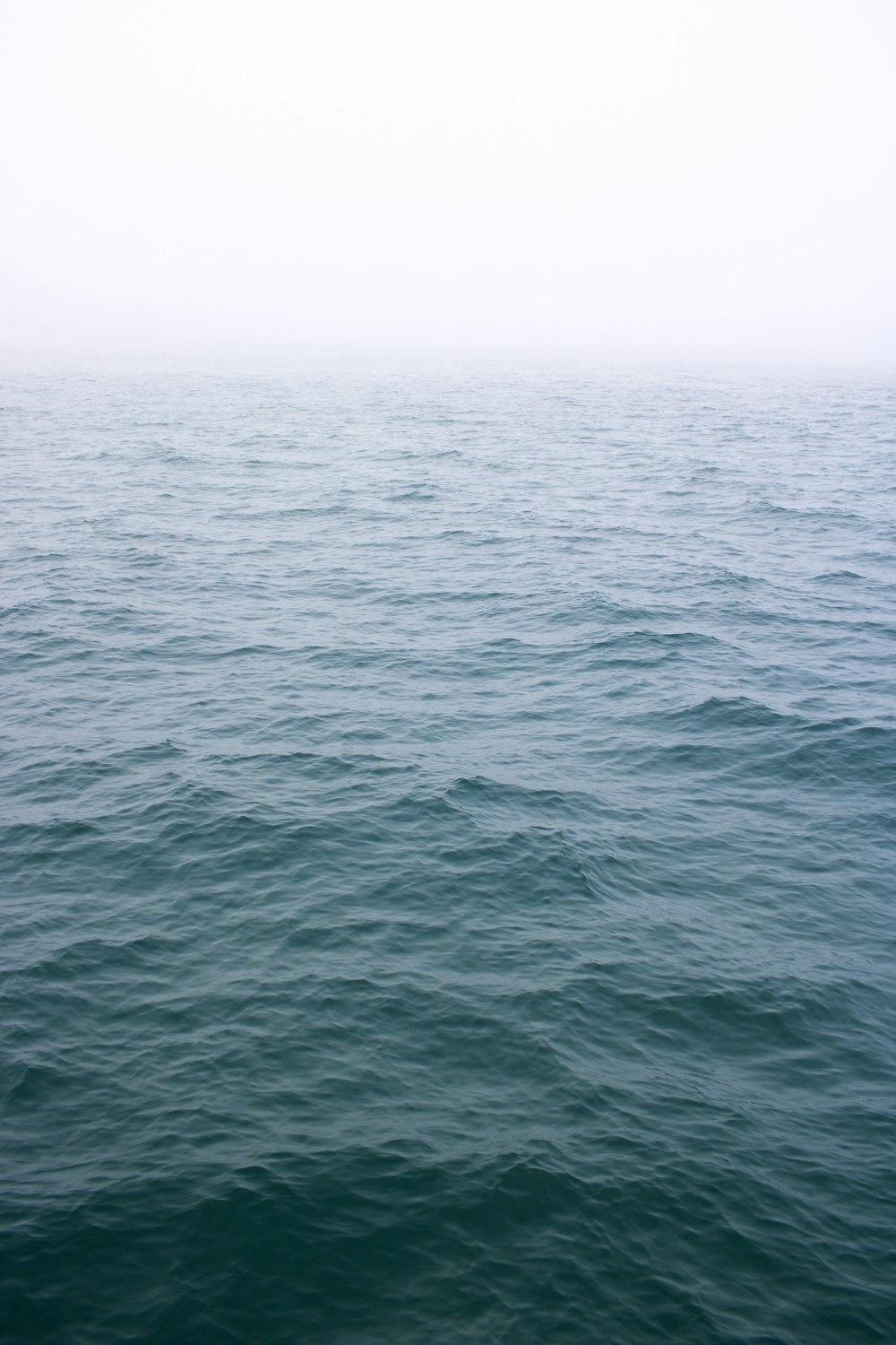 body of water under white sky during daytime