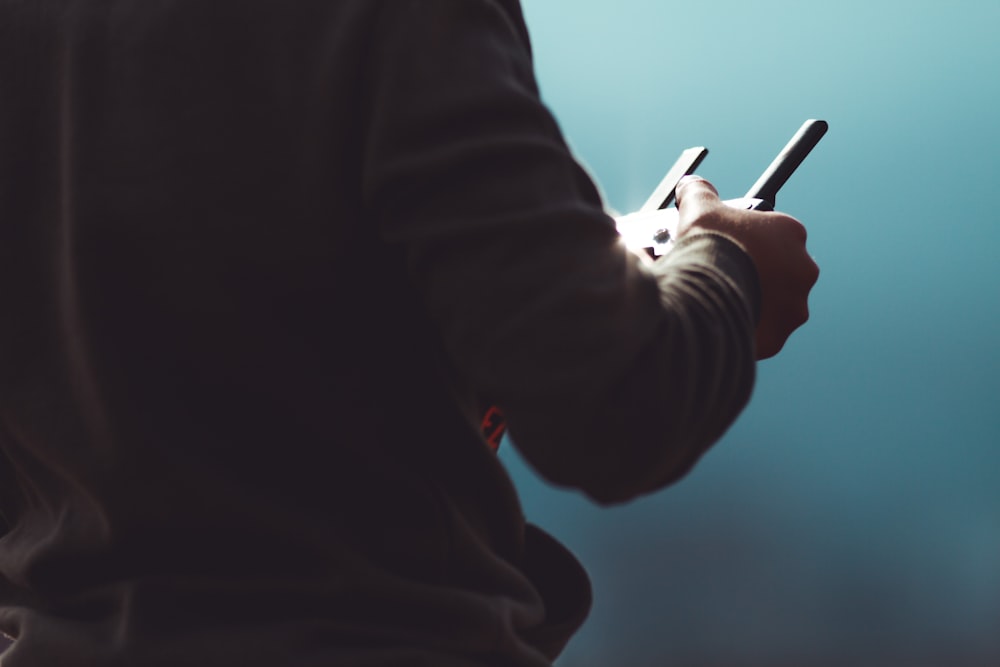 person in black long sleeve shirt holding black pen