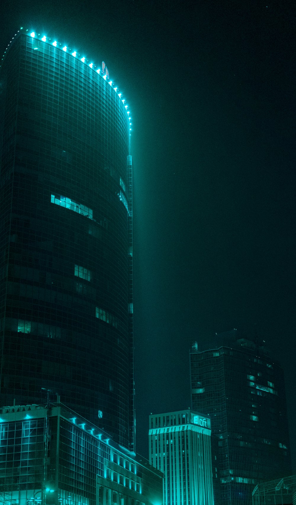 edifício alto preto e azul durante a noite