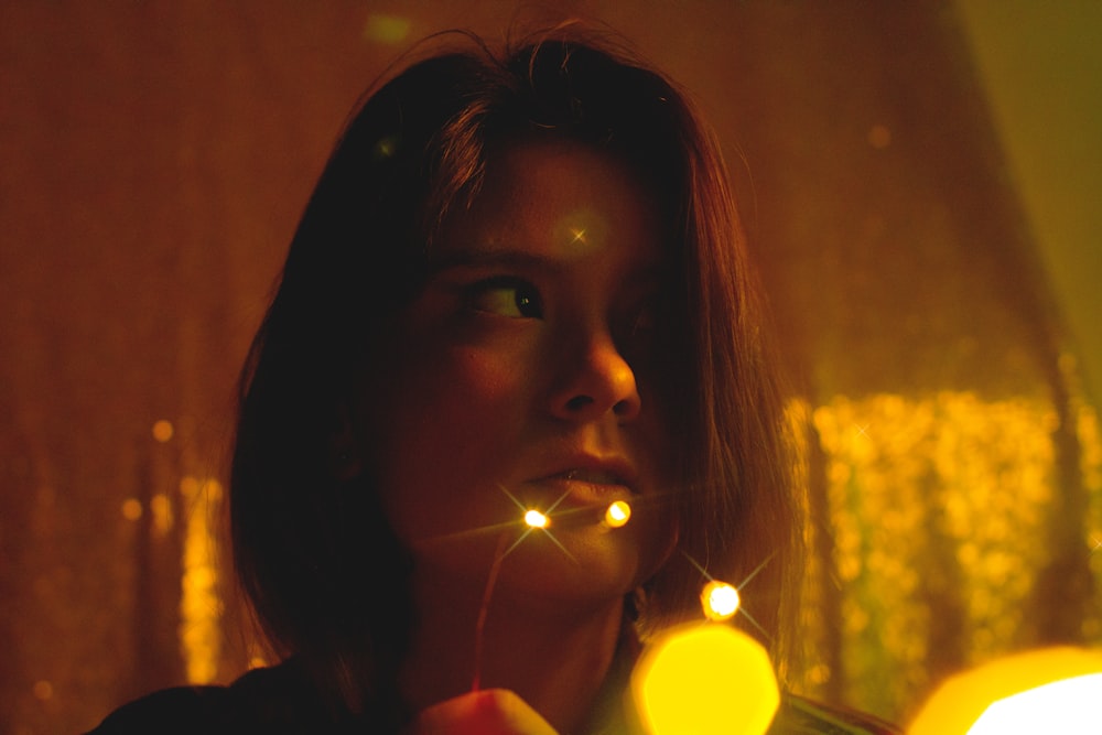 girl holding lighted candle during nighttime