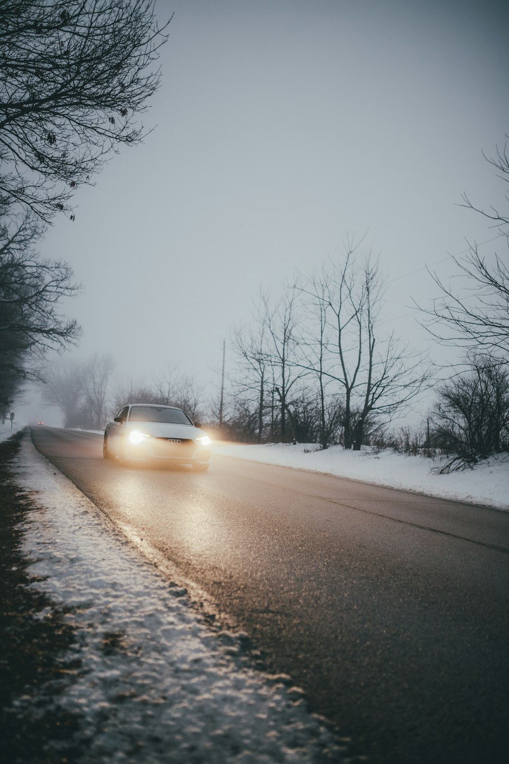 car on road covered with snow during daytime