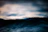 Close-up of a cozy hoodie fabric with ocean waves softly blurred in the background.