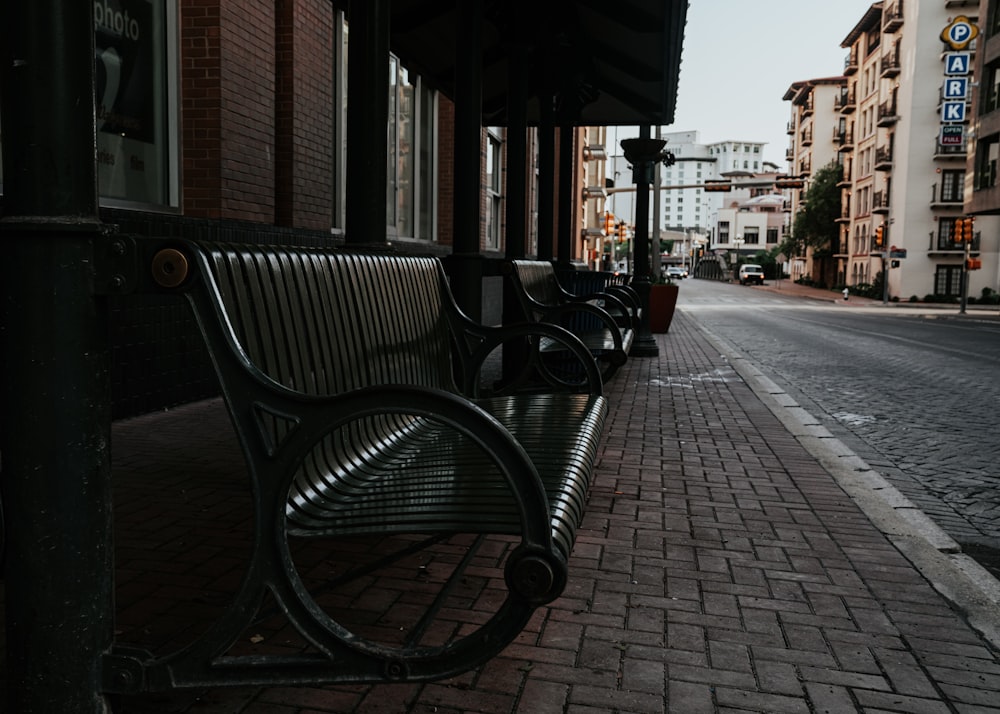 brown wooden bench on sidewalk during daytime