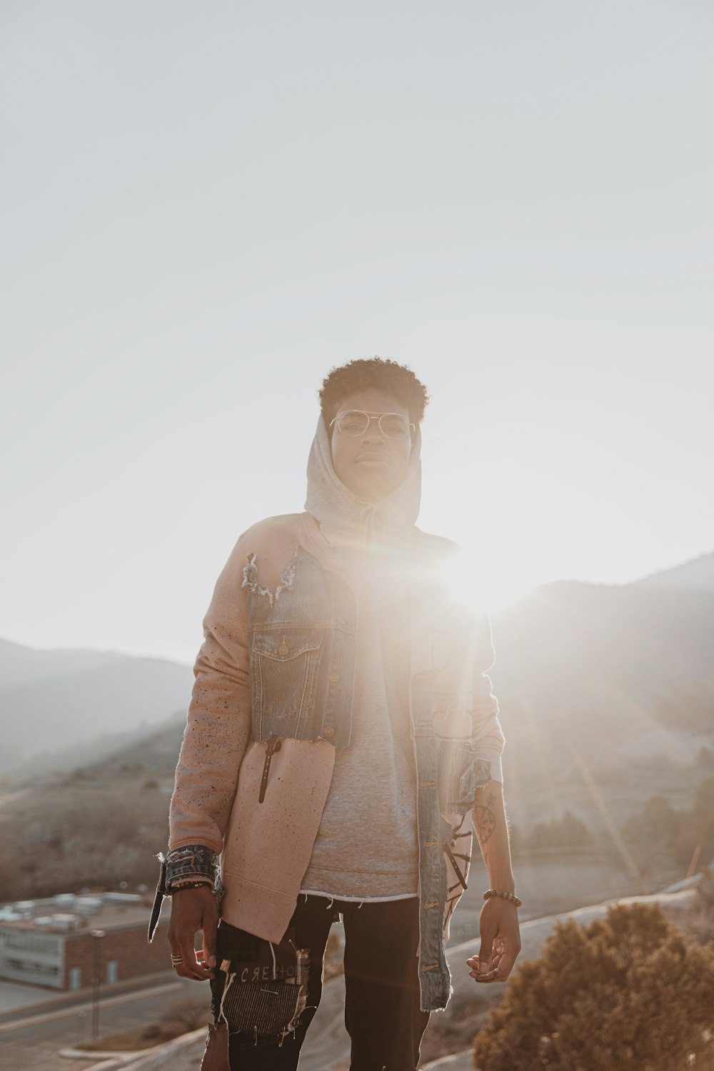 woman in brown long sleeve shirt standing on brown field during daytime