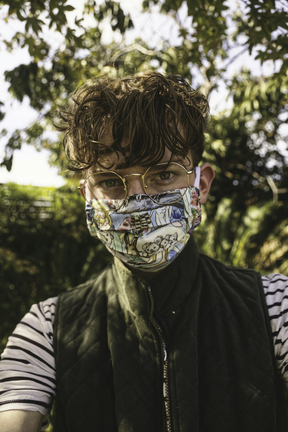 boy in green and black camouflage jacket wearing white mask