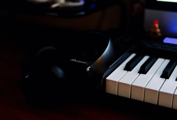 A close-up view of a piano with sheet music and a pair of headphones resting on top.