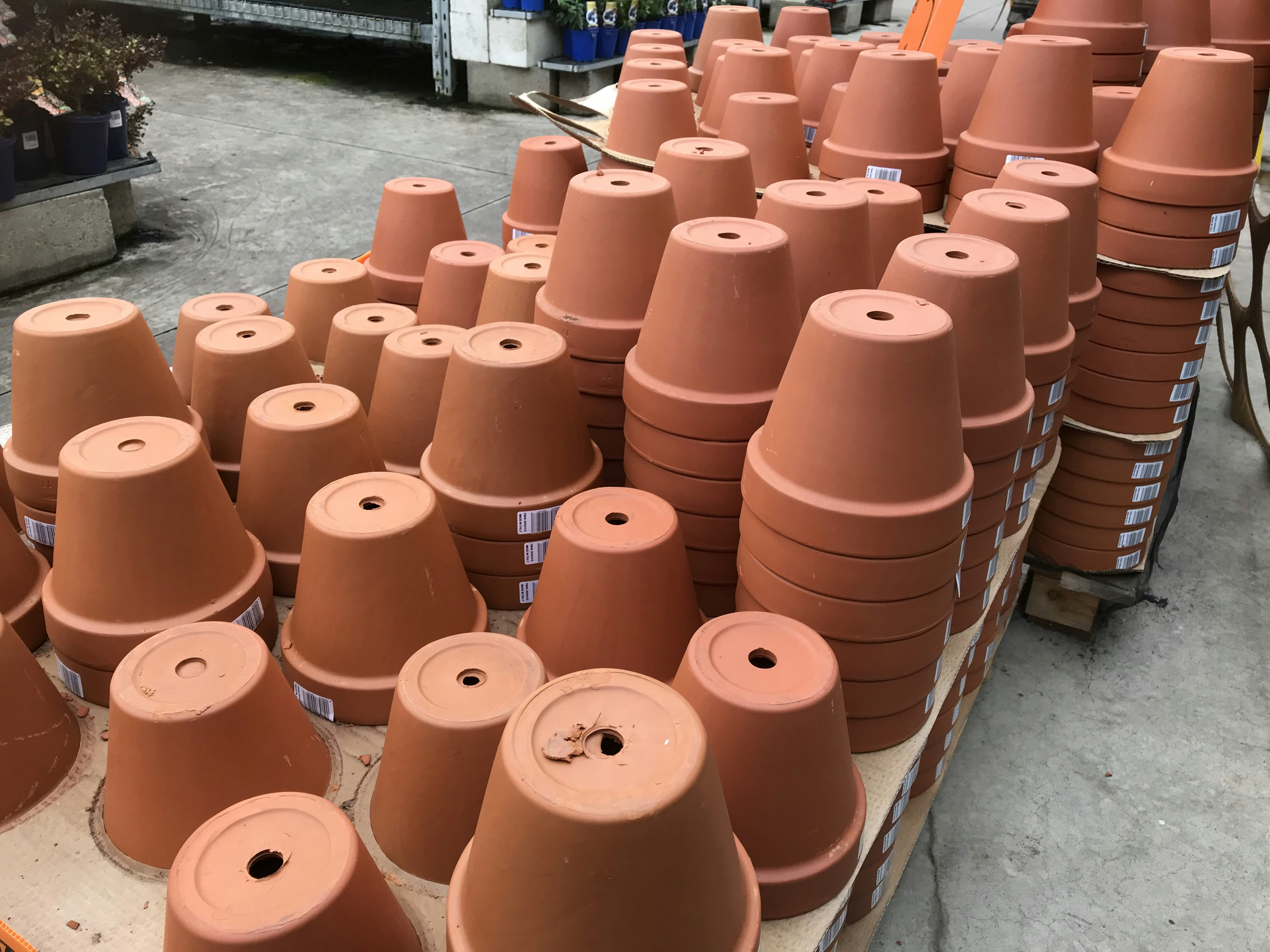 Set of three concrete-textured fabric grow bags arranged on terracotta tiled balcony