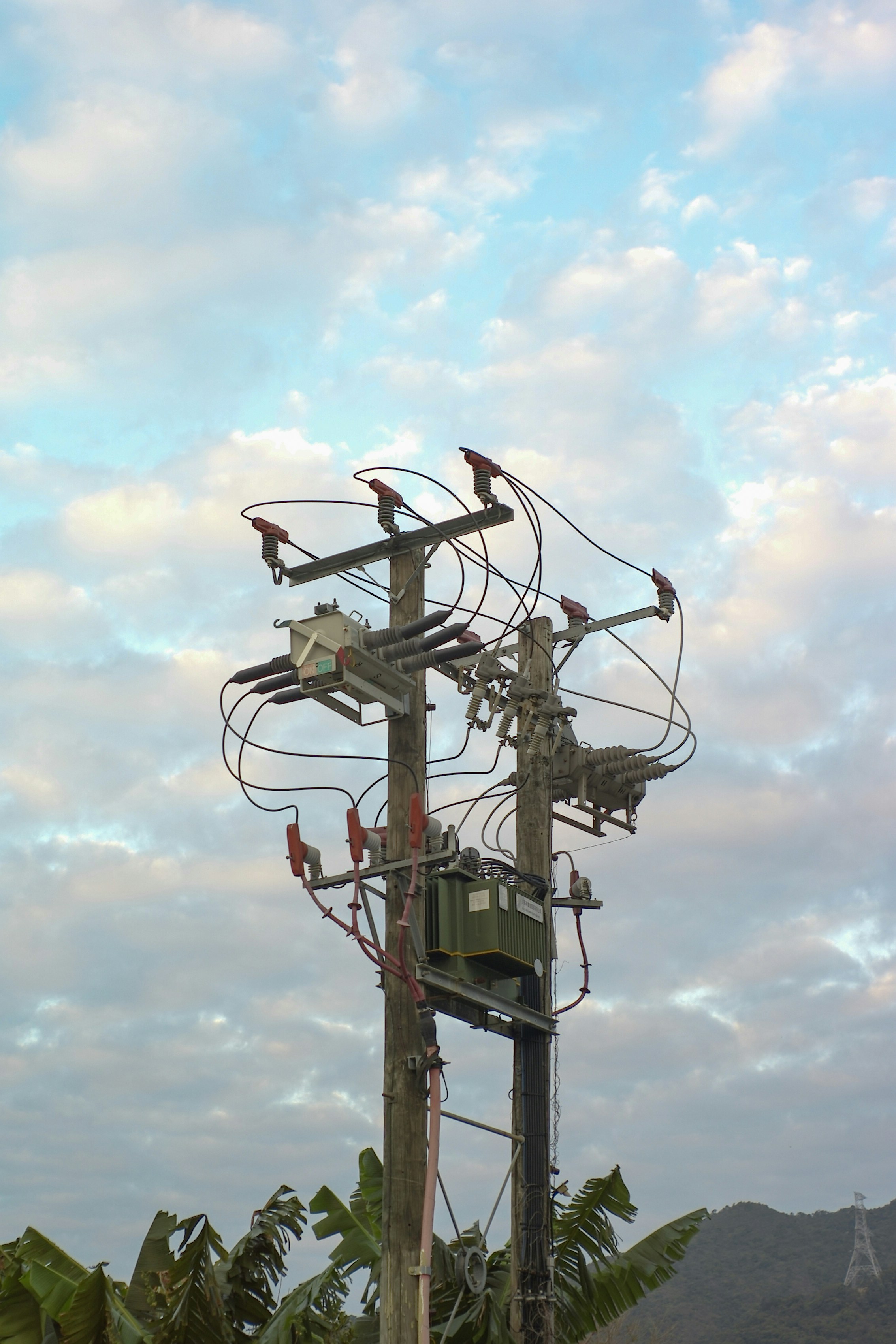 black electricity post under white clouds