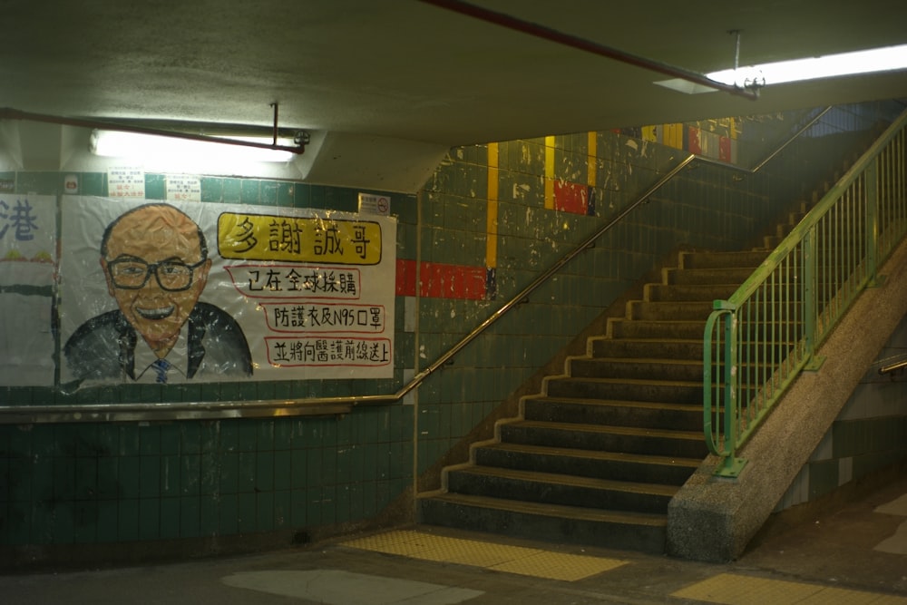 gray concrete staircase with green metal railings